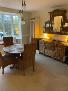 a dining room with a table and chairs and a mirror at Belle-Vue in Truro