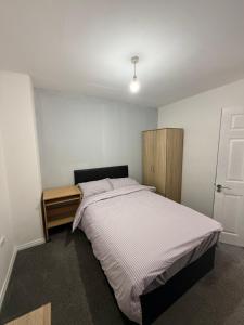 a bedroom with a bed and a wooden cabinet at 10 wyeverne road in Cardiff