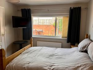 a bedroom with a large bed and a window at Peaceful Coastal Escape in Old Colwyn