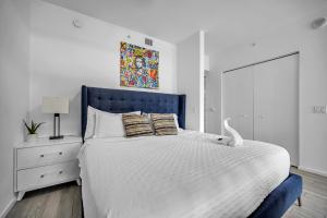 a bedroom with a large bed with a blue headboard at The Sanctuary King studio in Miami +23 photos