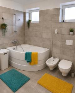 a bathroom with a tub and a toilet and a sink at Steffi Apartment in Balş +6 photos