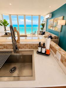 a kitchen with a sink and a view of the ocean at Beachfront Stella Maris Apt on Condado Ave in San Juan