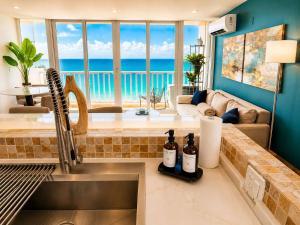 a kitchen with a sink with a view of the ocean at Beachfront Stella Maris Apt on Condado Ave in San Juan