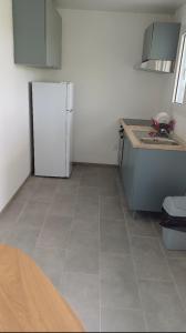 a kitchen with a white refrigerator and a tile floor at Maya Dream in Morne Blanc