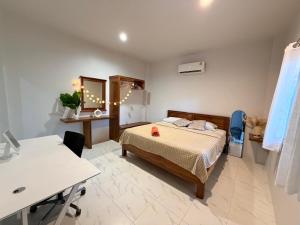 a bedroom with a bed and a desk and a table at Diamond House in Srithanu in Srithanu