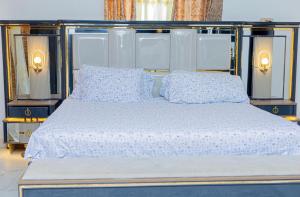 a bed with two pillows on top of it at Sowe's Villa in Old Yundum