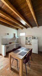 a kitchen with a wooden table and chairs at Apartamentos Violante in Tuineje