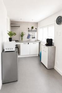 a kitchen with white cabinets and white appliances at Petite maisonnette avec accés piscine in Montauban