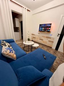 a blue couch in a living room with a tv at Green Door House in Vlorë +2 photos