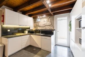 a kitchen with white cabinets and a sink at GuestReady - Porto Home GuestHouse in Porto