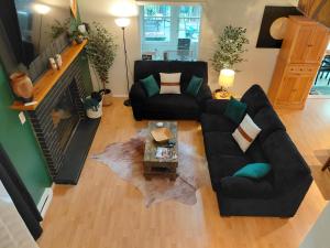 a living room with a black couch and a table at LAKEFRONT CHALET in THE BURCHES in Tobyhanna