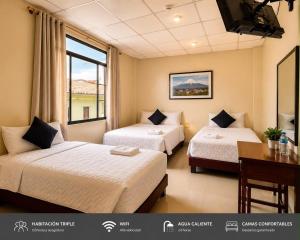 a hotel room with two beds and a desk at Hostal Marín Central - Quito in Quito +19 photos