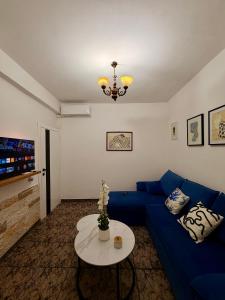 a living room with a blue couch and a table at Green Door House in Vlorë