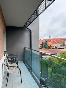 a balcony with chairs and a table on a building at City Centre Balcony Apartments in Wadowice