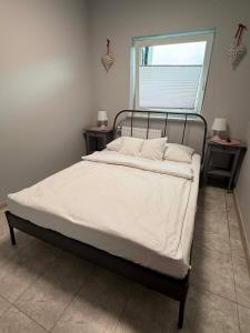 a bed with white sheets and pillows in a bedroom at City Centre Balcony Apartments in Wadowice