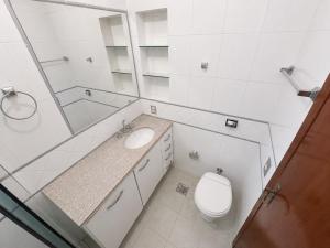 a bathroom with a toilet and a sink and a mirror at Morada 360 Casa Inteira para até 09 Pessoas in Sumaré