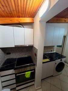 a kitchen with white cabinets and a stove at Green Door House in Vlorë