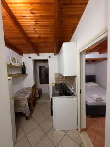 a room with a kitchen and a bedroom with a bed at Green Door House in Vlorë