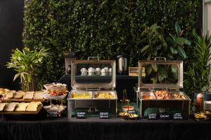 a table with various pastries and other food items at ibis Budget Auckland Airport in Auckland