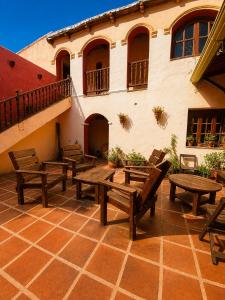 a patio with wooden tables and benches in front of a building at Hostal sabana Tilcara in Tilcara