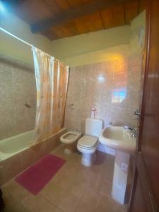 a bathroom with a toilet and a sink and a tub at Hostal sabana Tilcara in Tilcara