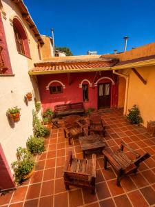 an outdoor patio with wooden benches and a building at Hostal sabana Tilcara in Tilcara