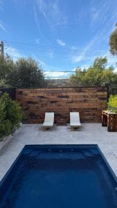 two chairs and a swimming pool with a wooden fence at Mustang Studios in Canberra