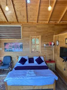 a bedroom with a blue bed in a wooden room at Fashet alsalt-فشة السلط in Al Salt