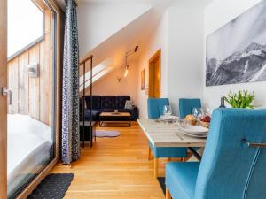 a dining room with a table and blue chairs at Bösenstein in Hohentauern