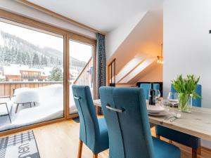 a dining room with a table and chairs and a large window at Bösenstein in Hohentauern