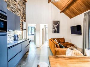 a living room with a brown couch in a kitchen at SeeZeit am Pressegger See in Lake Pressegg +14 photos