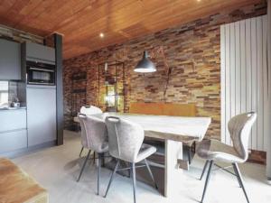 a kitchen with a table and chairs and a brick wall at Seeglück am Pressegger See in Lake Pressegg