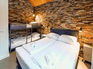 a bedroom with two bunk beds in a brick wall at SeeZeit am Pressegger See in Lake Pressegg
