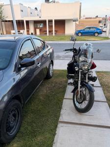 a motorcycle is parked next to a car at Casa spello in Gómez