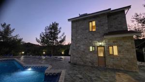 a stone house with a pool in front of it at Platres Villas in Kato Platres