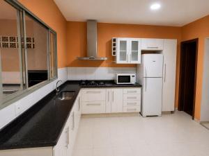 a kitchen with white cabinets and a white refrigerator at Morada 360 Casa Inteira para até 09 Pessoas in Sumaré +5 photos