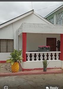 a small house with a balcony and two plants at Wrens cosy home in Diani Beach