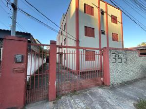 a red fence in front of a building at Apartamento simples no centro de Lavras com garagem in Lavras