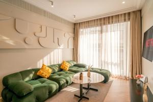 a living room with a green couch and a table at VIVASTAY Casablanca -Corniche Le claridge Emerauld with gym and rooftop in Casablanca