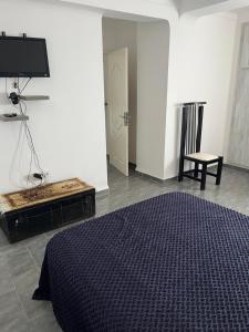 a bedroom with a bed and a tv and a chair at T2 vue sur mer in Bejaïa
