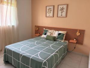 a bedroom with a large bed with a wooden headboard at Villa de charme à Matoury in Matoury
