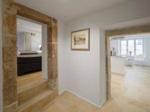 a room with a hallway with a bed and a mirror at Domresidenz Regensburg in Regensburg