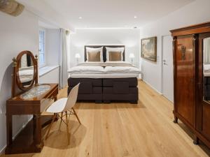 a bedroom with a large bed with a desk and a mirror at Domresidenz Regensburg in Regensburg