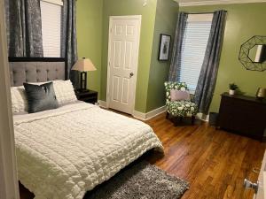 a bedroom with green walls and a bed and a chair at Cute 2 bedroom home ! in Augusta