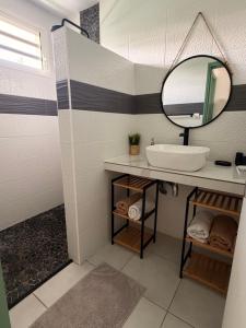 a bathroom with a sink and a mirror at Villa de charme à Matoury in Matoury +16 photos