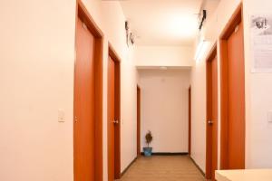 an empty hallway with orange doors and a potted plant at Super Collection O Sayhallo Kanchan in Bhubaneshwar