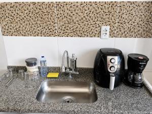 a kitchen counter with a sink and a toaster at Studio in Barbacena +12 photos