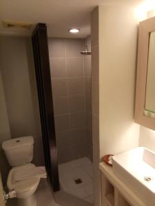 a bathroom with a shower and a toilet and a sink at Almont City Hotel in Butuan