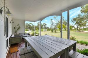 a large deck with a wooden table and benches at La Sila Homestead on Marrowbone in Mount View