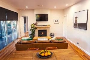 a living room with a couch and a fireplace at Fig Tree Luxury Guest House in Pokolbin